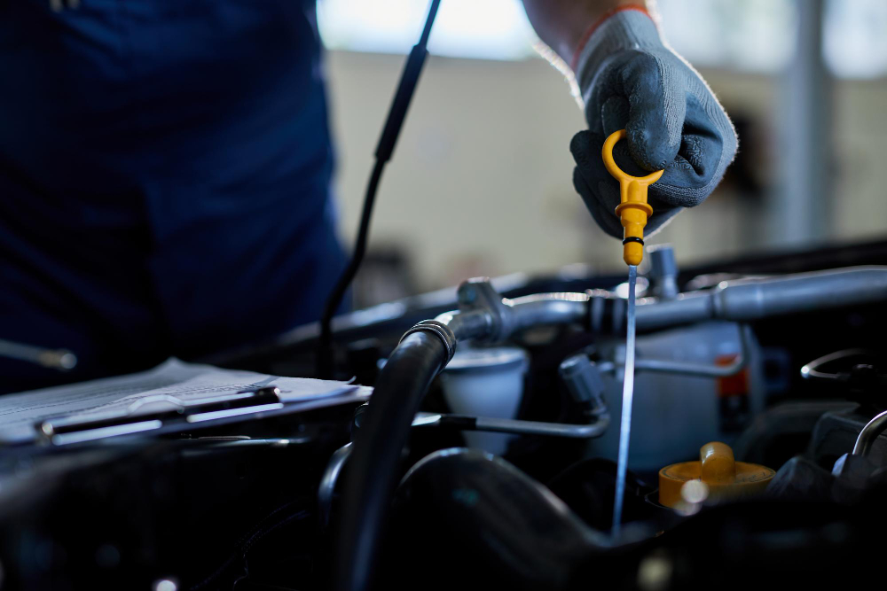 closeup auto repairman checking car oil workshop
