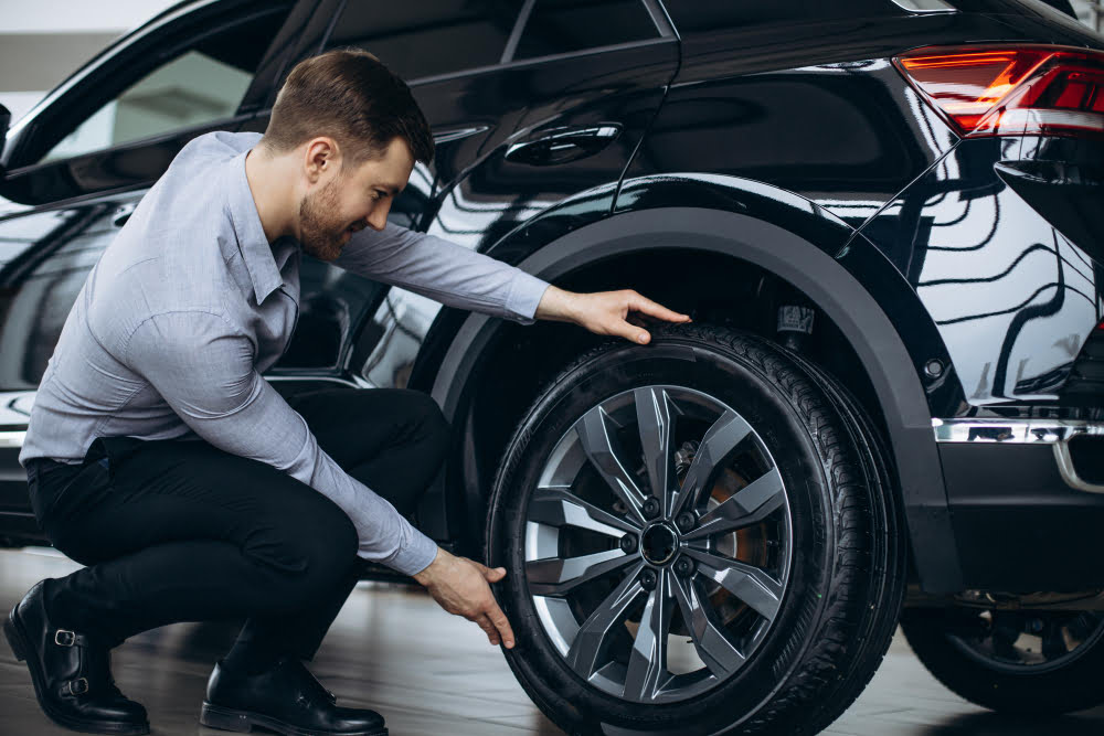 10 dicas para prolongar a vida útil dos pneus do carro 1 man choosing car checking tires 1