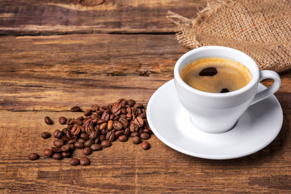 Benefícios do Café para a Saúde: Como aproveitar? 3 xicara de cafe em uma mesa de madeira parede escura